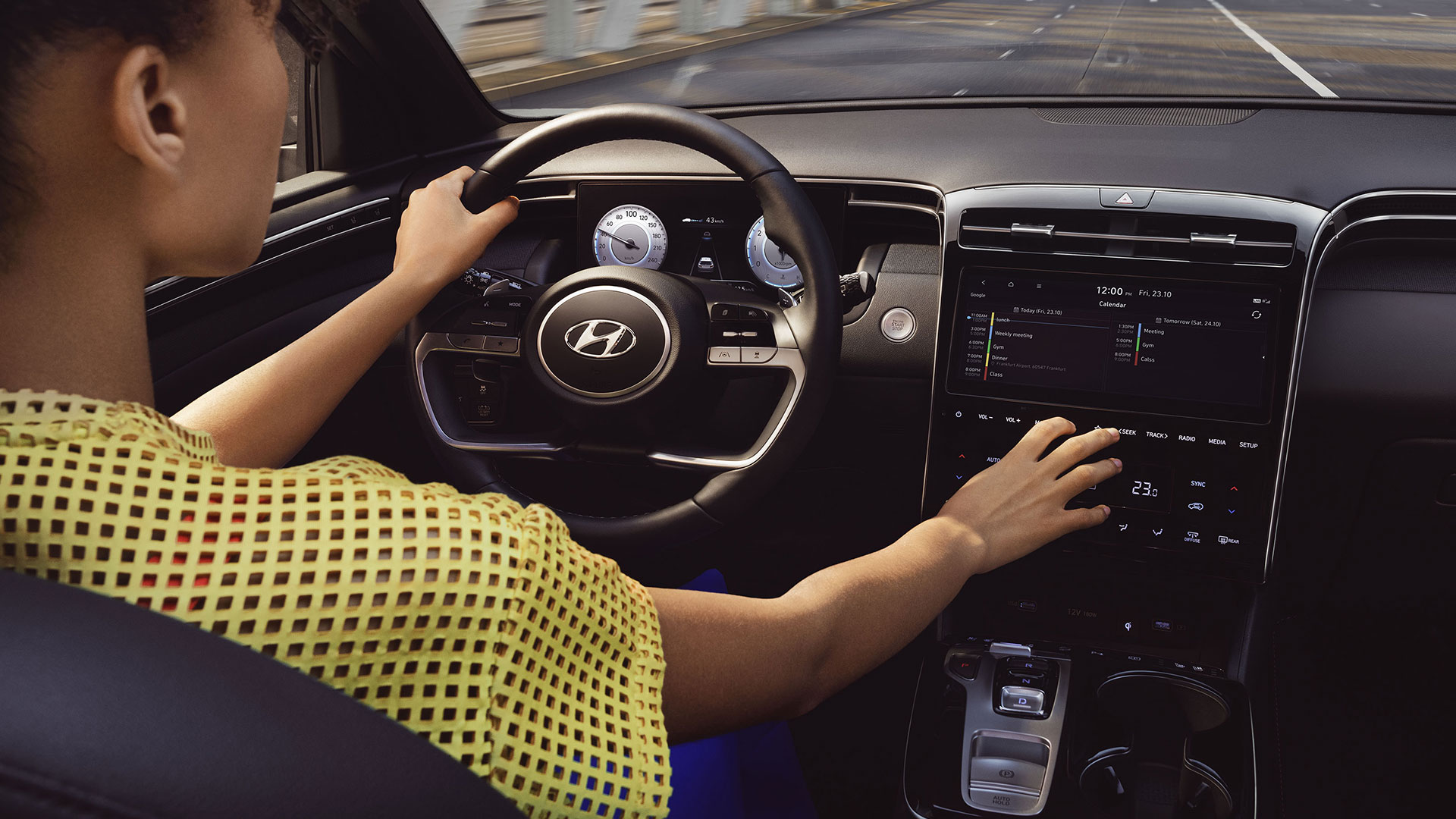 Pohled na interiér SUV Hyundai TUCSON a řidiče, používajícího dotykovou obrazovku